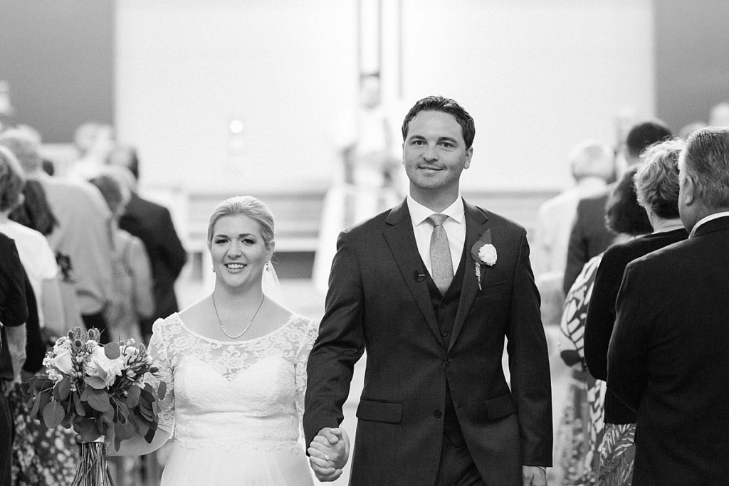Just married picture of bride and groom walking back down aisle at St. Andrew Lutheran Church in Minnesota