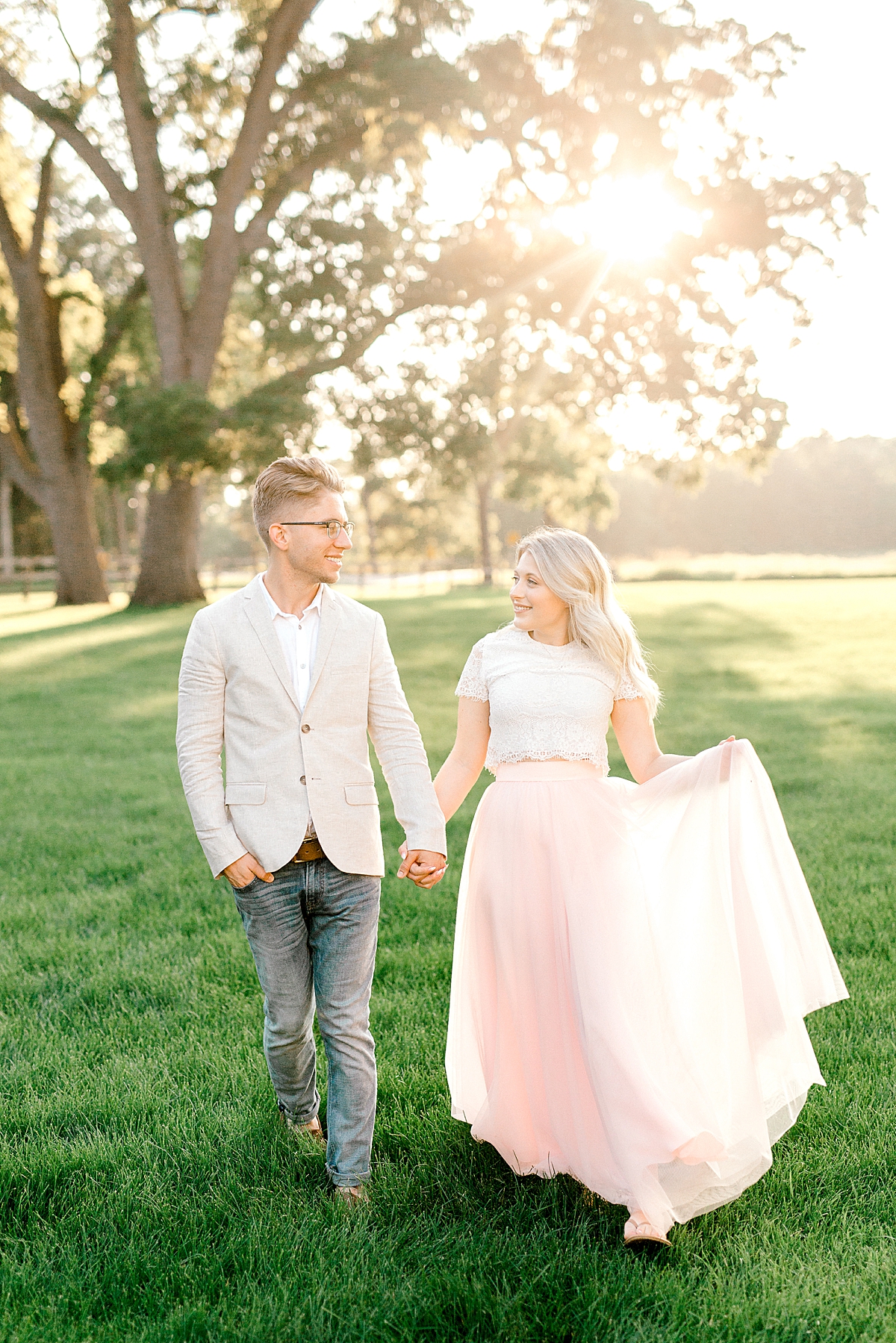 Engagement picture of couple walking with pink skirt at Mayowood Stone Barn
